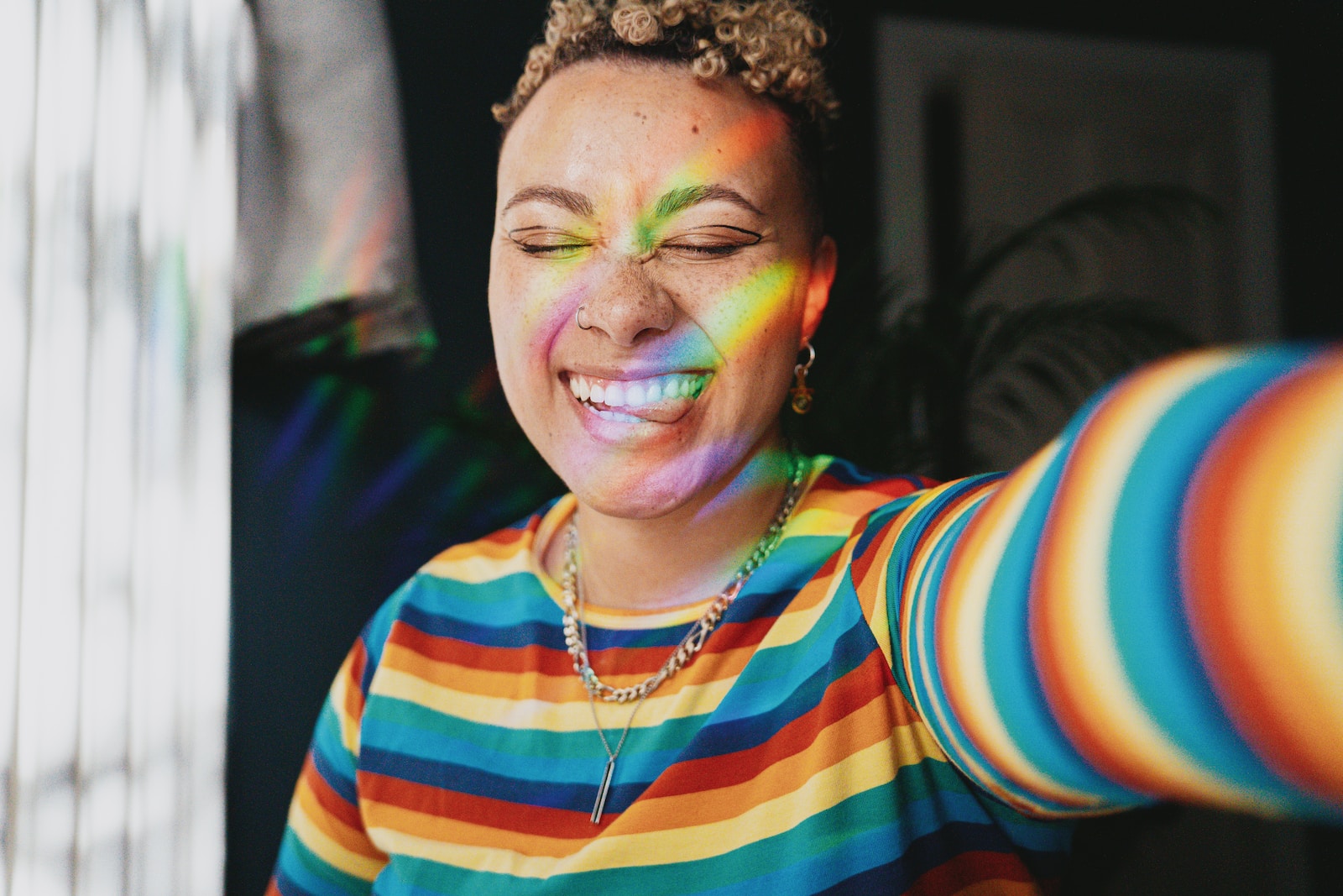 Portrait of nonbinary autistic person wearing a rainbow sweater